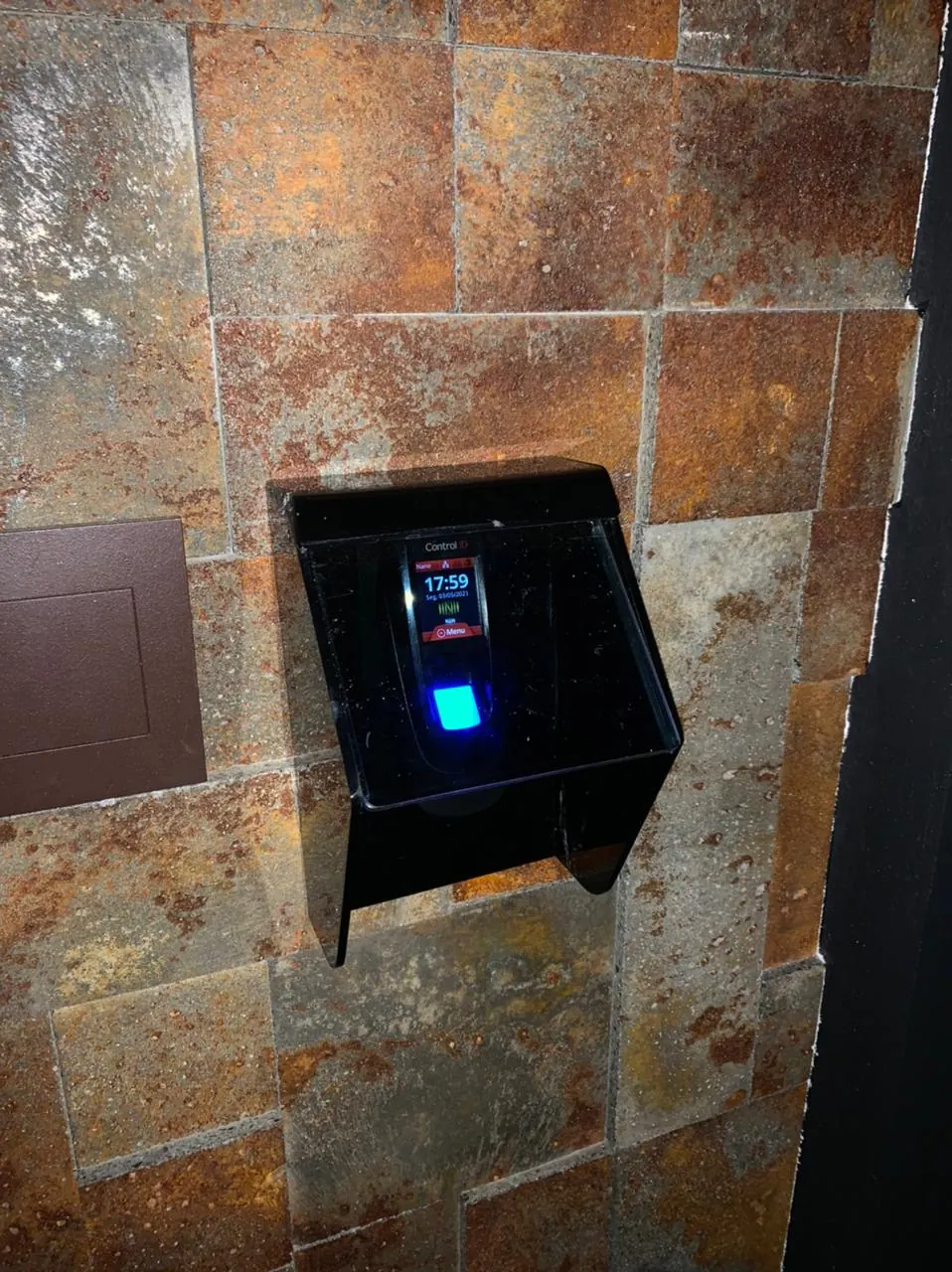 Leitor biométrico com capa de proteção em parede de pedra