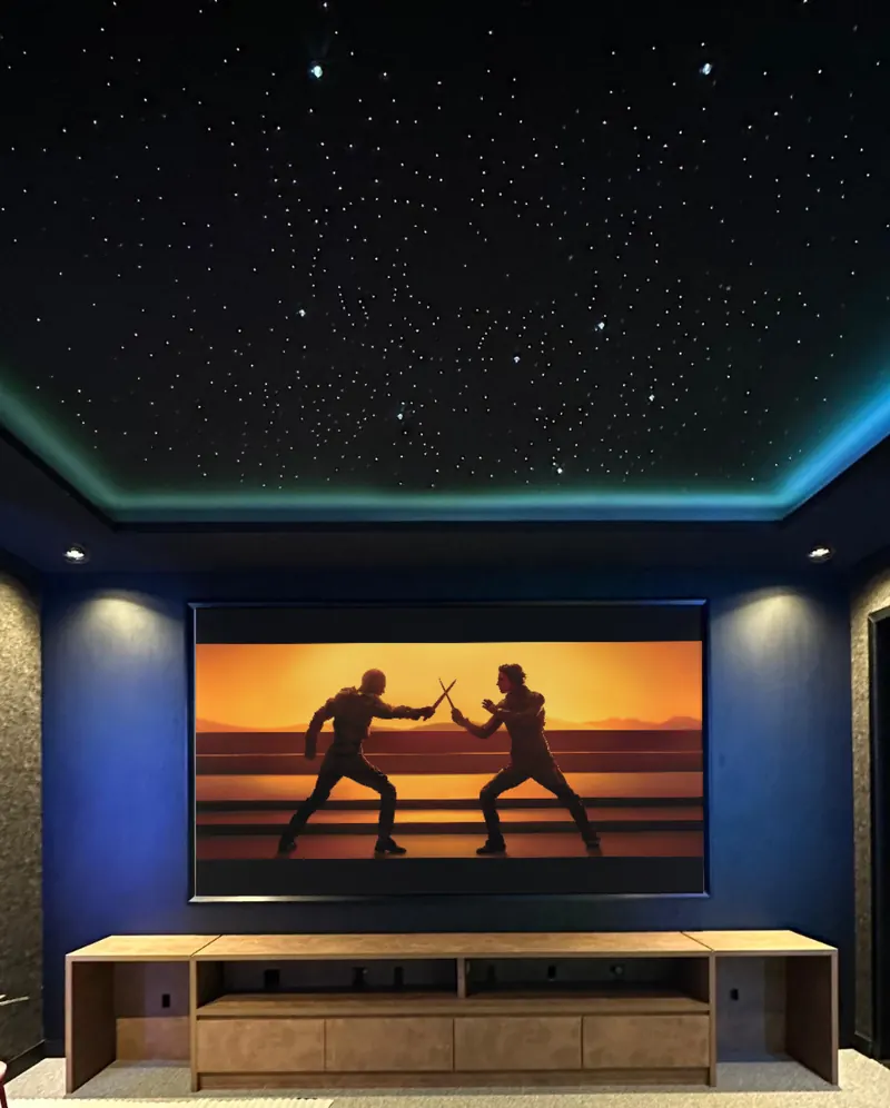 Home theater with a starry ceiling, indirect blue lighting and a movie on the screen