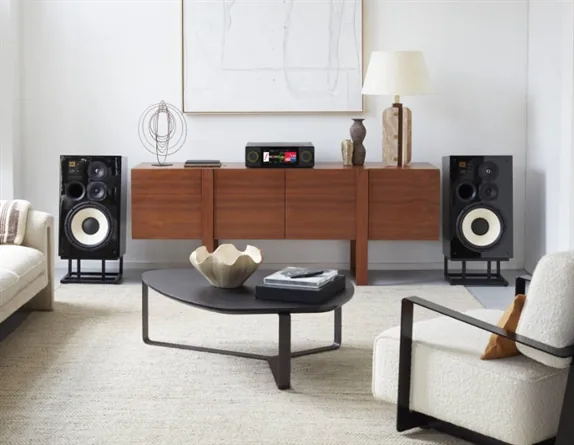 Sala de estar com caixas acústicas e amplificador Arcam sobre o móvel