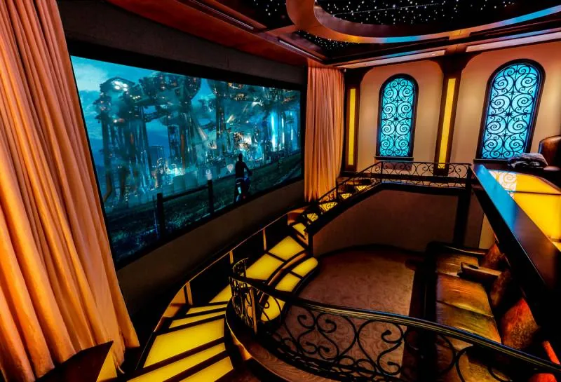 Sala de cinema com sistema JBL Synthesis e tela projetada