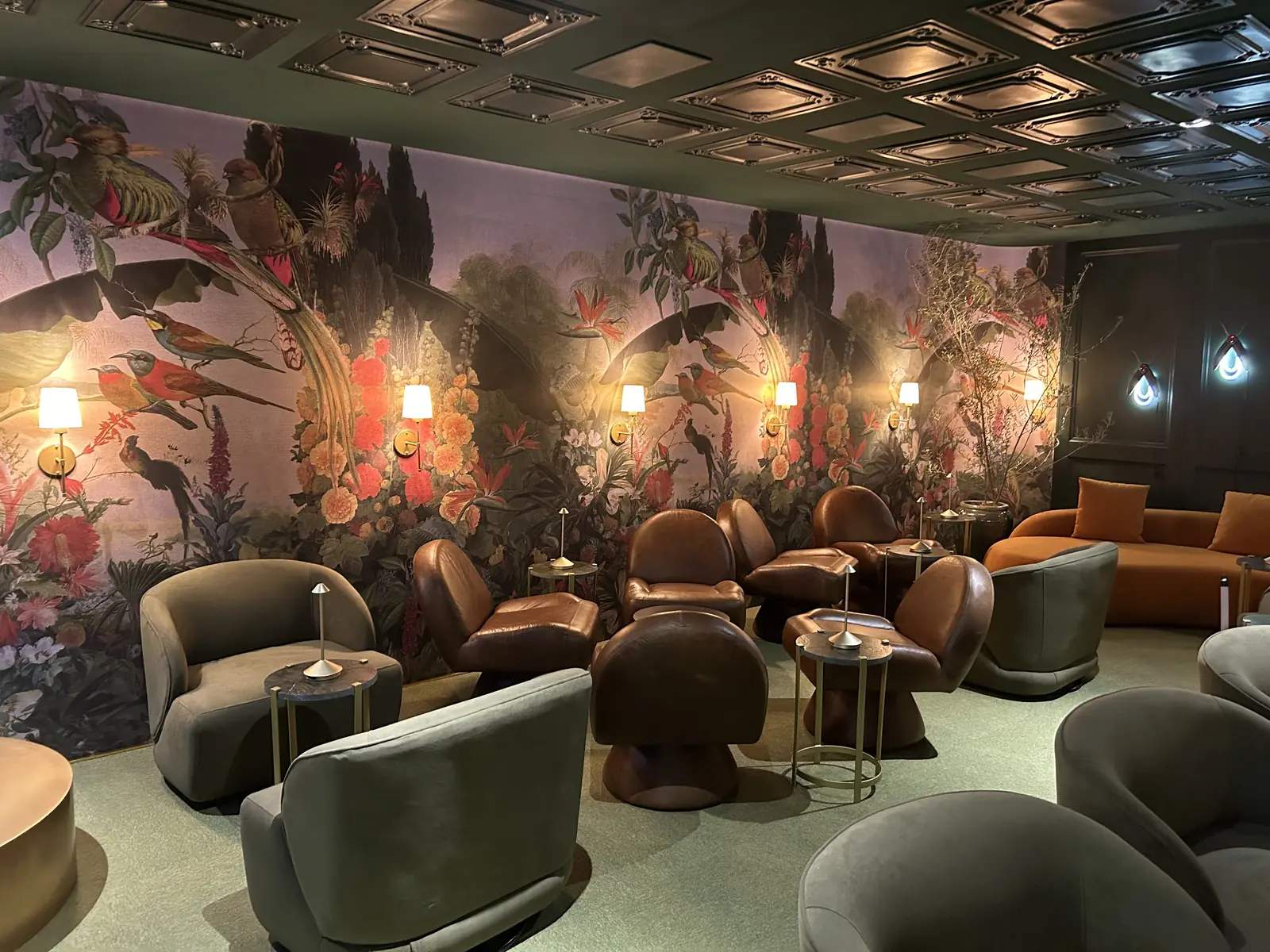 The Secret Bar at Casa Cor SP, with a floral mural, armchairs and scenic lighting
