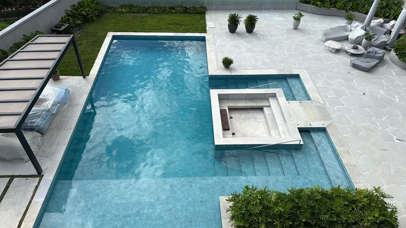 Pool seen from above, with a stone deck and garden