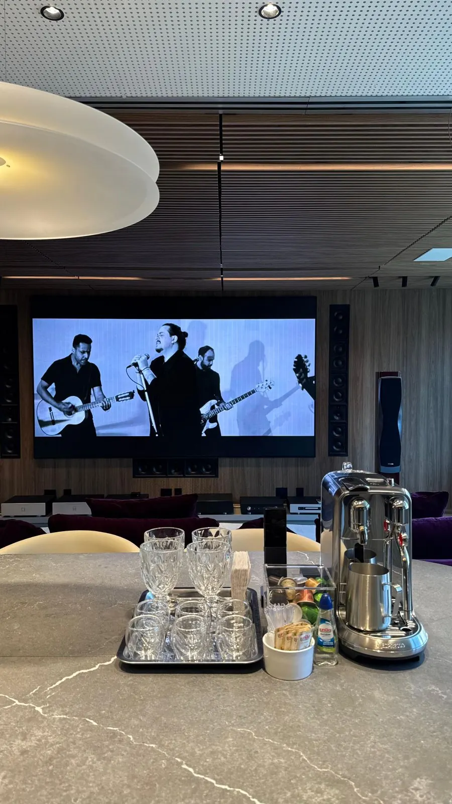 Show exibido em tela grande na sala, com caixas acústicas embutidas no painel