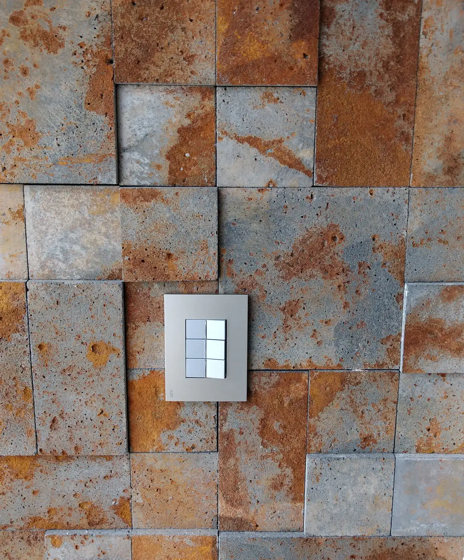Automation keypad in a metallic finish on a stone wall